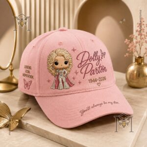 Close-up of the front of the pink Dolly Parton hat cap with a blurred framed photo