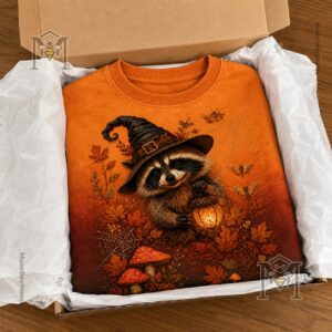 Raccoon Witch Autumn Magic Halloween Sweatshirt - detailed view of lower right design with mushrooms and logo